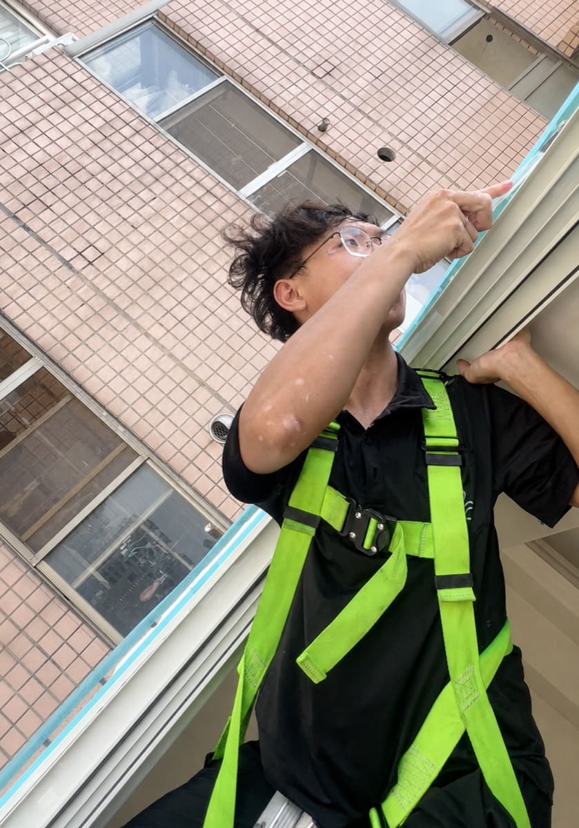 高樓施工師傅穿戴綠色安全帶作業