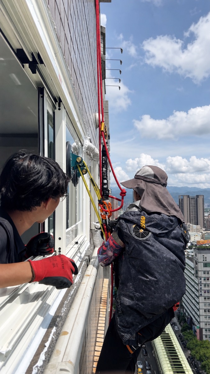 施工人員以繩索垂降方式進行高樓外側施工